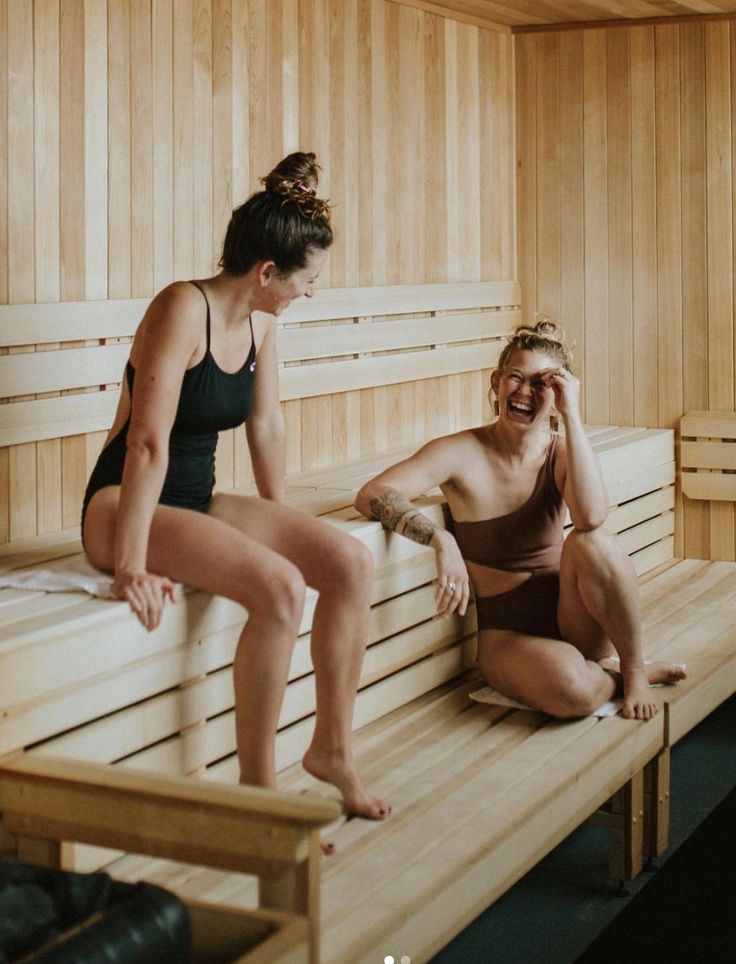 Two friends laughing together in a cedar sauna